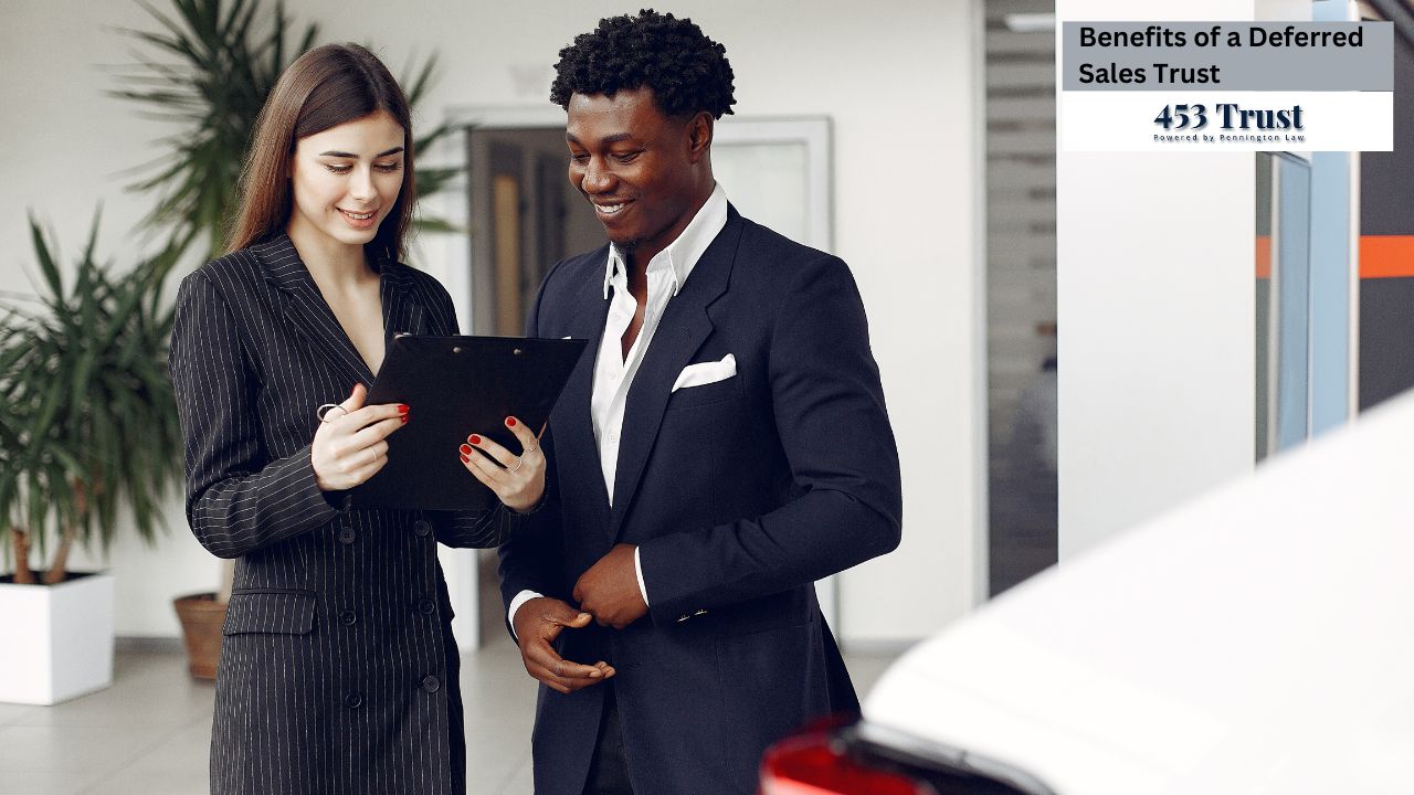 A man and woman in formal suits are observing a clipboard, suggesting they are reviewing important information or documents. The setting appears to be indoors, likely in a business environment. They both display professional attire indicative of their roles as businesspersons.