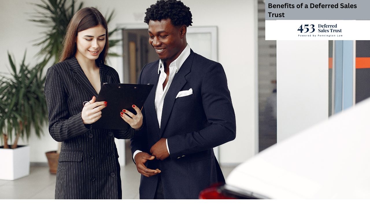 A man and woman in formal suits are observing a clipboard, suggesting they are reviewing important information or documents. The setting appears to be indoors, likely in a business environment. They both display professional attire indicative of their roles as businesspersons.
