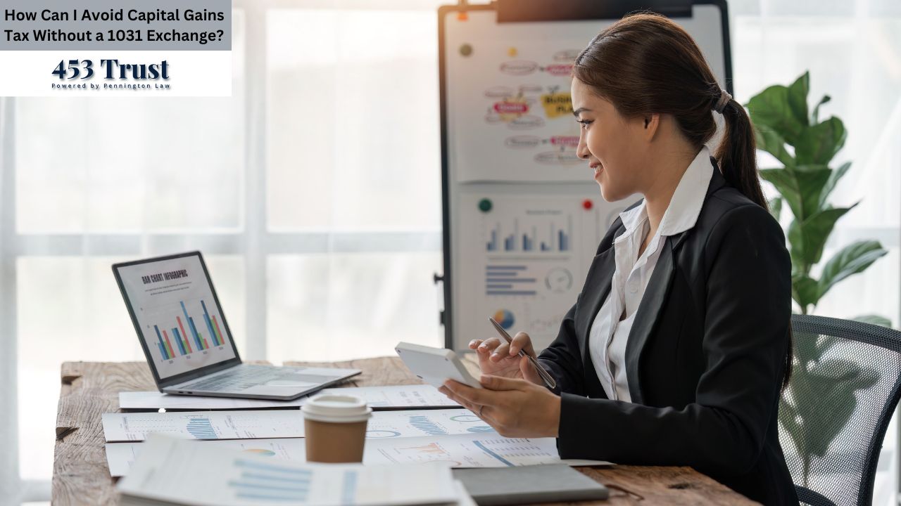 A woman in a black business suit sits at a wooden desk, looking at papers and a laptop. The laptop screen displays bar graphs. A tablet computer rests on the desk in front of her. The background includes a white board with various charts and graphs, and greenery.