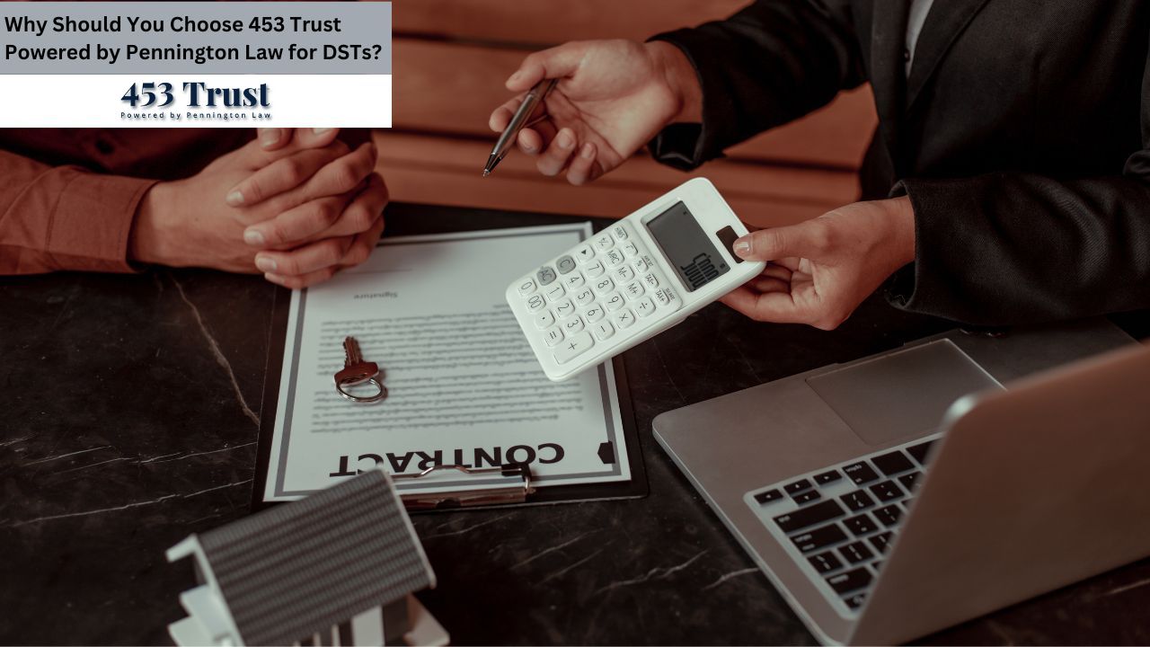 A real estate transaction is being finalized, with two individuals reviewing documents, a calculator, and a house key on a dark table.